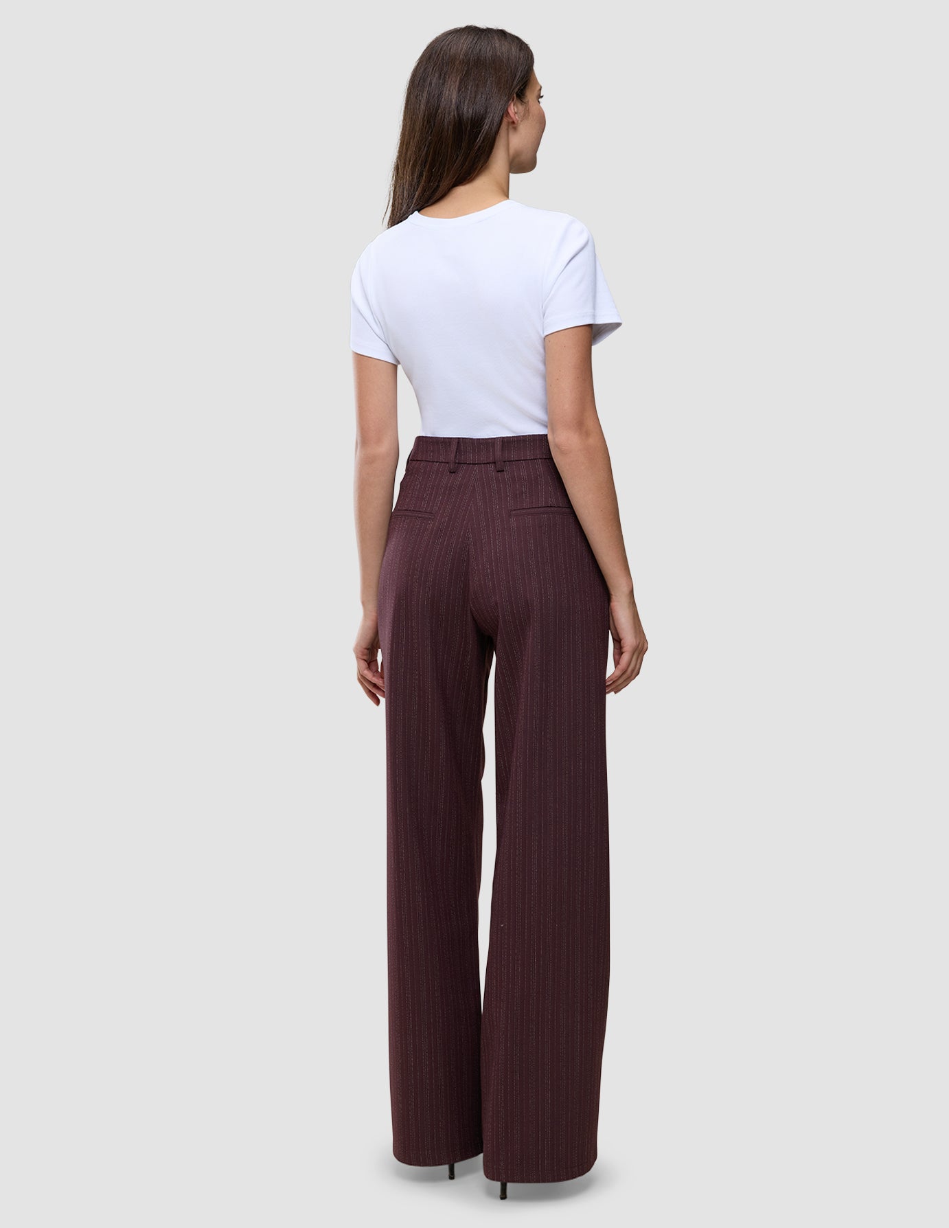 En kvinde set bagfra, iført en hvid T-shirt og et par Women Serene Pants Wide Berry Pinstripe.